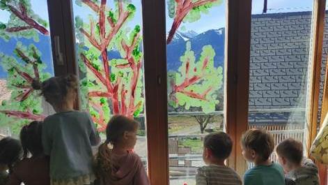 Eine Gruppe von Kindern betrachtet ein Gemälde an einer Wand